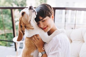 Mujer abrazando a su perro después de contratar un seguro para mascotas