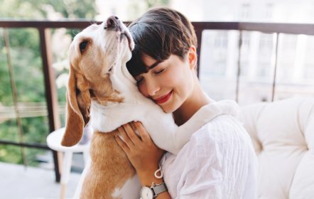 Mujer abrazando a su perro después de contratar un seguro para mascotas