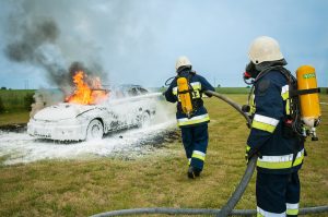 Hombres con distintos tipos de extintores apagando auto