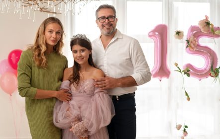 Niña celebrando sus 15 años junto a sus padres