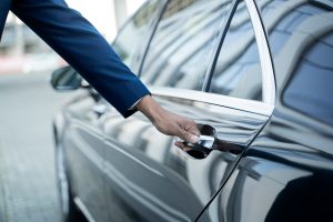 Persona abriendo la puerta de un auto